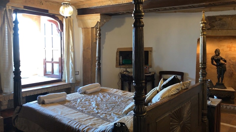 Hotel Killa Bhawan Jaisalmer Fort photo of room interior with ornate bed and window seat